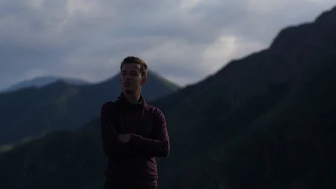 Young handsome man walking in the mountains. A man tourist walks on the Stock Footage 105983103