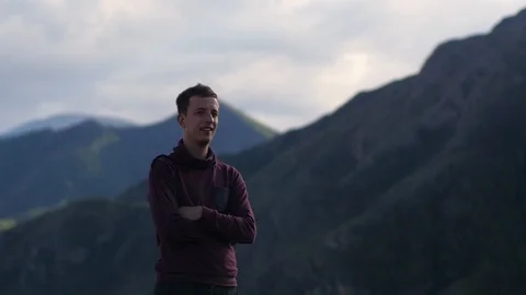 Young handsome man walking in the mountains. A man tourist walks on the Video stock 105983186