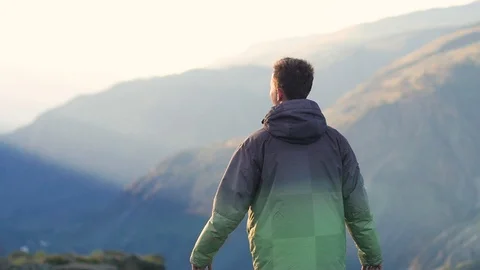 Young handsome man walking in the mountains. A man tourist walks on the Vídeo Stock 106102537