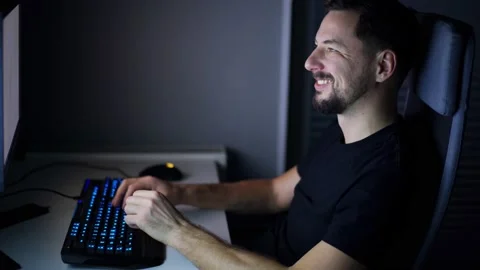 Young handsome man is working on desktop at night. Chats, laughs. Stock Footage 169107331