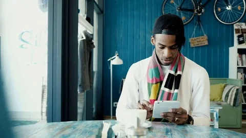 Young handsome man working on a tablet, drinking coffee in a cafe Stock Footage 75892197