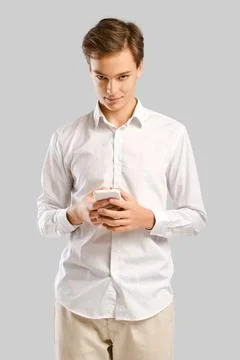 Young handsome man write message on smartphone and looking from under the for Foto stock