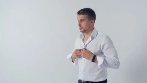 A young handsome mans buttons up his shirt Video stock 83595873