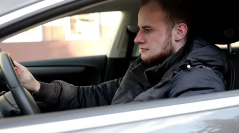 Young, handsome men with beard sitting inside the car and checking mirrors. Stock Footage 49338324