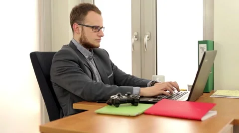 Young, handsome men sitting behind the desk and in using computer Stock Footage 49341277