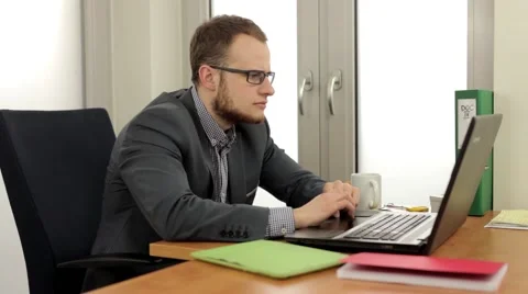 Young, handsome men sitting behind the desk and using computer Stock Footage 49341509