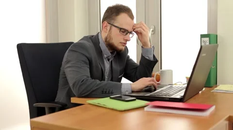 Young, handsome men sitting behind the desk and using computer. Stock Footage 49341911