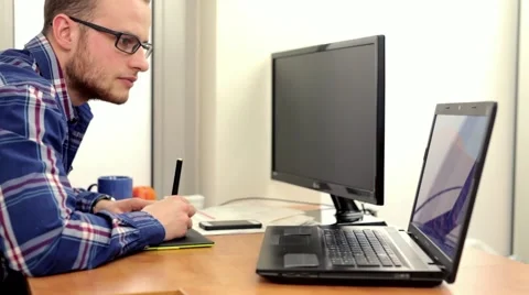 Young, handsome men sitting beind the deska and using computer.. Stock Footage 49057785
