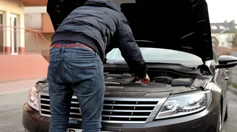 Young, handsome men standing behind his car and looking into engine. (2) Stock Footage 49337992