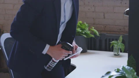 A young handsome middle-eastern man disinfects a desk surface with paper towel Stock Footage 136545716