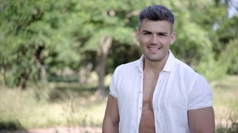 Young handsome model man posing in the city park. European guy with an adorable Stock-Footage 90966573