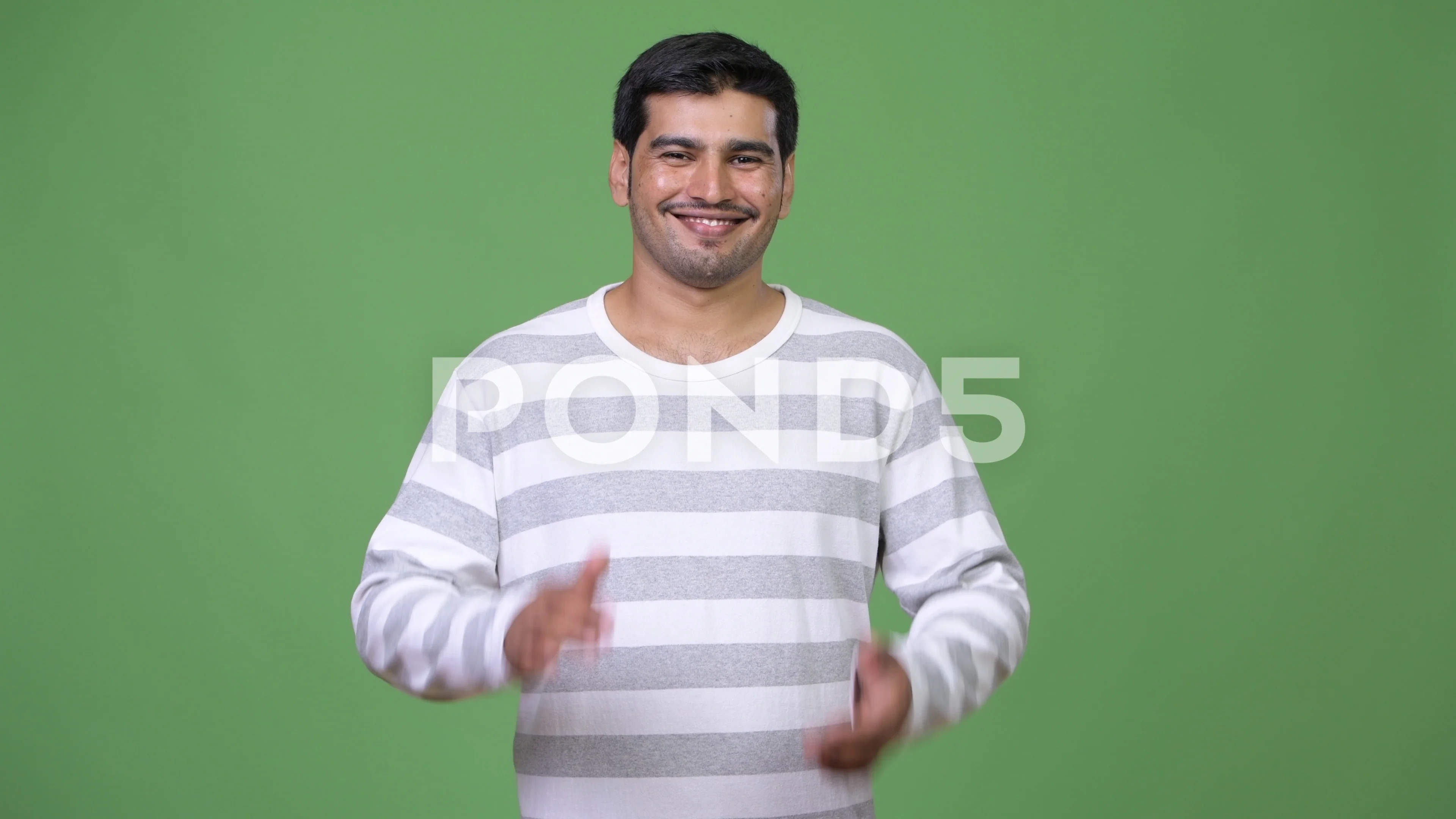 Young handsome Persian man clapping hands