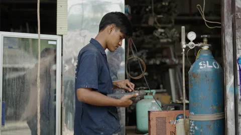 Young handsome real worker using an angle grinder and smiling to the camera Stock Footage 232586267