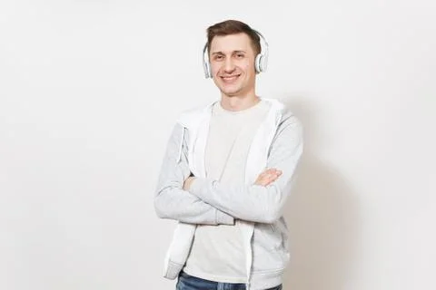 Young handsome smiling man student in t-shirt and light sweatshirt listening  Stock Photos