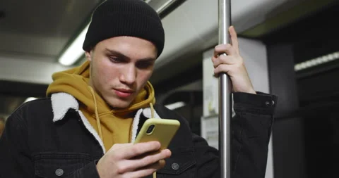 Young handsome student using smartphone and smiling while commuting on public 動画素材 137044235