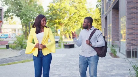 Young handsome students are talking to each other. Beautiful pair is walking Stock Footage 160111833