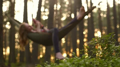 Young handsome tourist using mobile phone in hammock in the wood Stock Footage 170744625