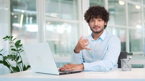 Young handsome worker shows index finger to camera and call me gesture while Stock Footage 237328808