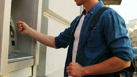 A young hansome man using an ATM machine. Outdoors. 動画素材 80799332