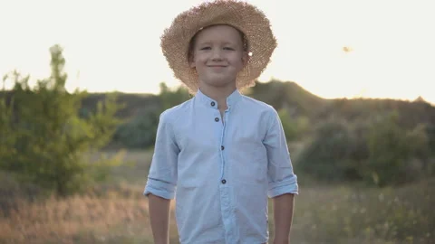 Young happy boy in the hat smiling on camera in the middle of the field Stock Footage 115987259