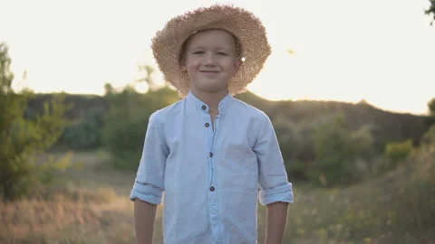 Young happy boy in the hat smiling on camera in the middle of the field Stock Footage 115988455