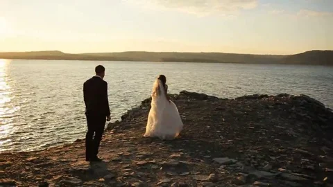 Young happy bride running from her handsome groom, but he catching her and Stock Footage 69150909
