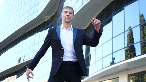 A young happy businessman in a business suit dancing modern ballet and wacking Stock Footage