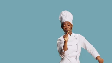 Young happy chef using wooden spoon to sing in studio Stock Footage 235395880