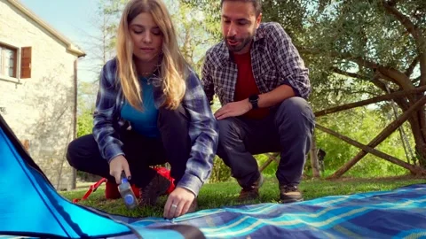 Young happy couple assembling tent together outdoors Stock-Footage 333386687