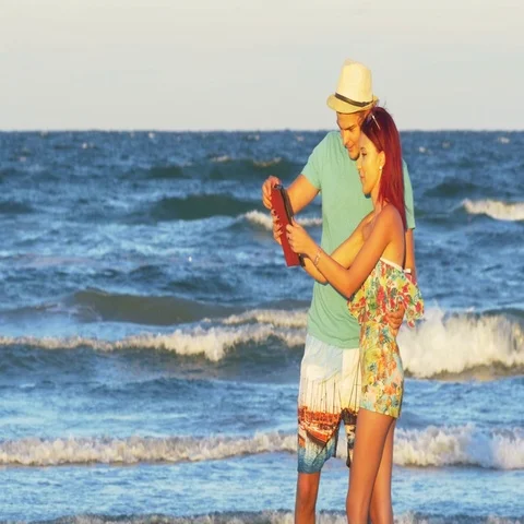Young happy couple on the beach having video chat on tablet pc Stock Footage 69699666