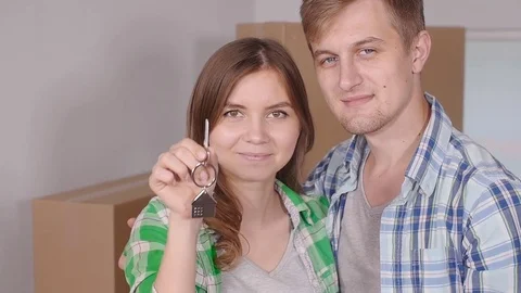 Young happy couple with boxes and holding flat keys Stock Footage 78659251