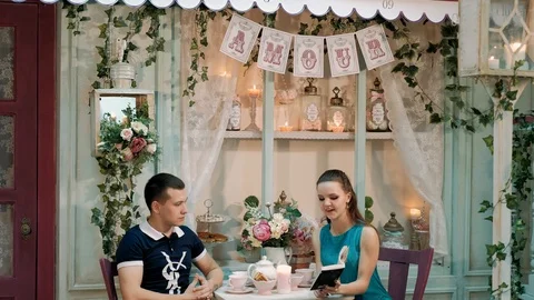 Young happy couple drinking coffee and having brunch at traditional cafe in Video stock 89444020