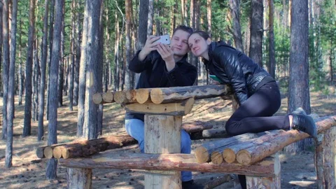 Young happy couple having fun taking self portrait photo with smartphone in park 스톡 동영상 75680751