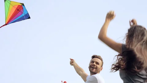 Young, happy couple having fun and playing with flying kite. Stock Footage 95481837