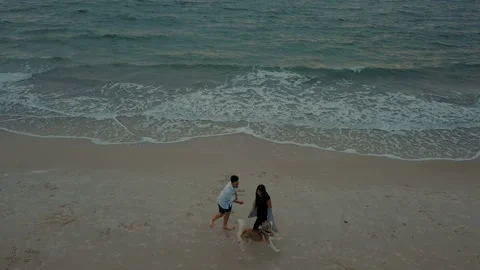 Young happy couple having fun with husky dog on beach Stock Footage 117361270