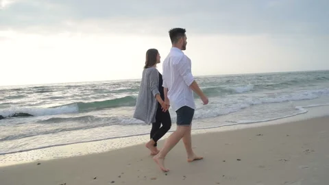 Young happy couple having fun with husky dog on beach Stock Footage 117362113