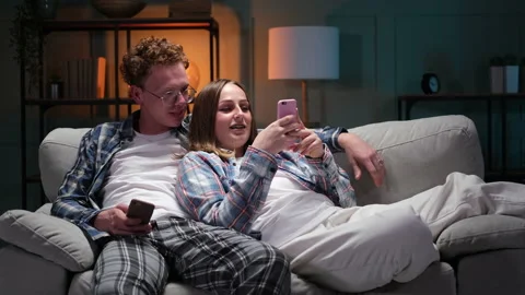 Young happy couple having fun using smartphone at home Stock Footage 166099163