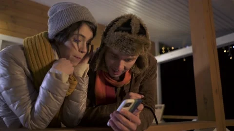 Young happy couple having fun using smartphone in chalet. Stock Footage 167650229
