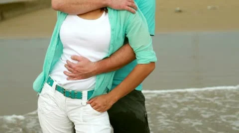 Young happy couple hugging at the beach Stockbeeldmateriaal 10758024