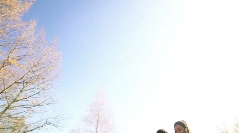Young happy couple listening to music on headphones at the park Stock Footage 59554747