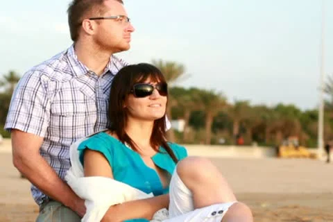 Young happy couple looking at something on the beach 스톡 동영상 10791787