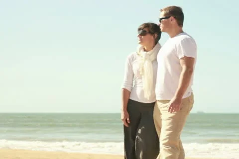 Young happy couple pointing at something on the beach 库存影片 10851375