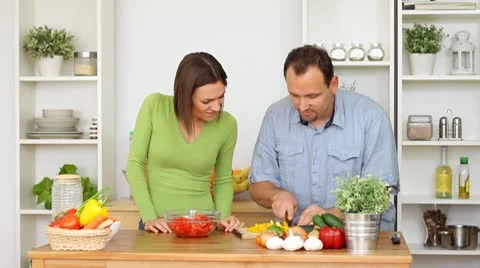 Young happy couple preparing salad at kitchen Stock Footage 8983389