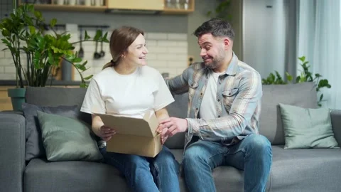 Young happy couple received a parcel, happy satisfied with shopping in online  Stock Footage 203029596