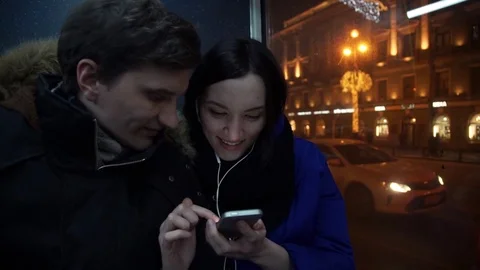 Young happy couple using smart phone looking at screen during bus ride Stock Footage 83873263