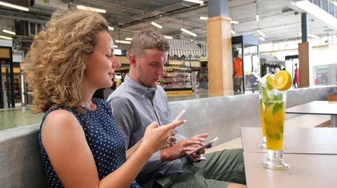 Young Happy Couple Using Smartphone in City Cafe Stock Footage 57524760