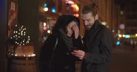 Young happy couple using smartphone at night. 動画素材 85097408