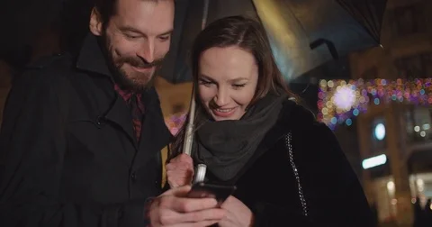 Young happy couple using smartphone at night. Stock Footage 85098210