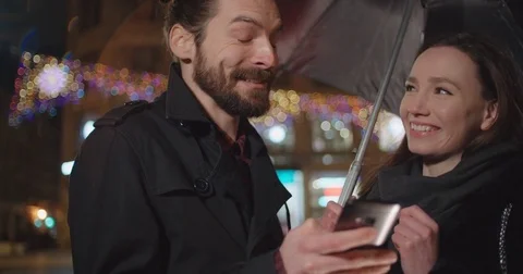 Young happy couple using smartphone at night. 動画素材 85098264