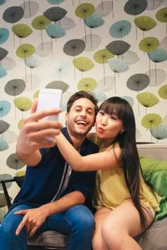 Young happy couple using smartphone in the bar Stock Photos